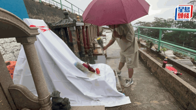 從深圳來的粉絲郝先生，冒雨向家駒墓碑獻花悼念。楊偉亨攝