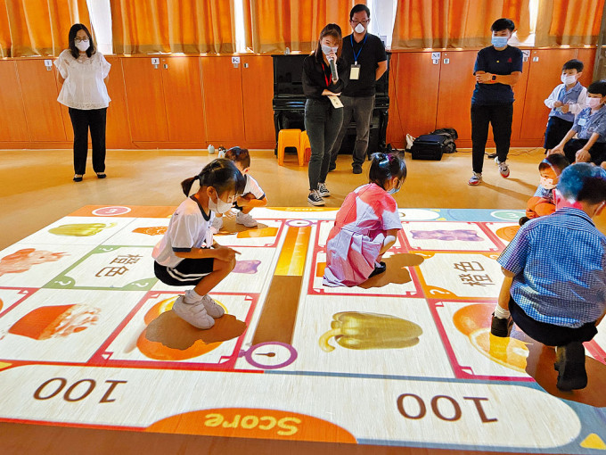 主風小學的小一學生在禮堂內，聽從教師指示參與活動，「尋找」題目需要的「物品」。　