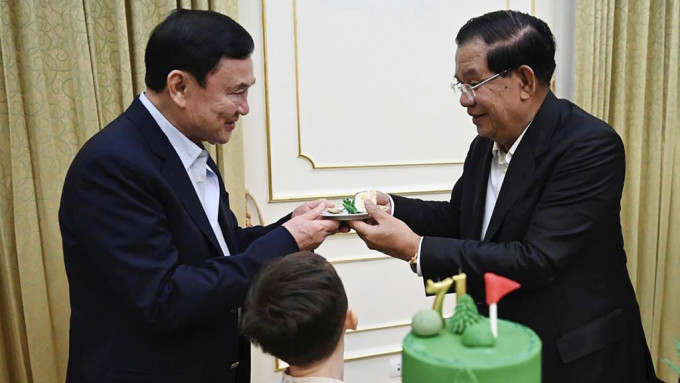 柬埔寨總理Telegram發布照片，顯示洪森（右）在71歲生日會上，將一片蛋糕遞給他信。 美聯社