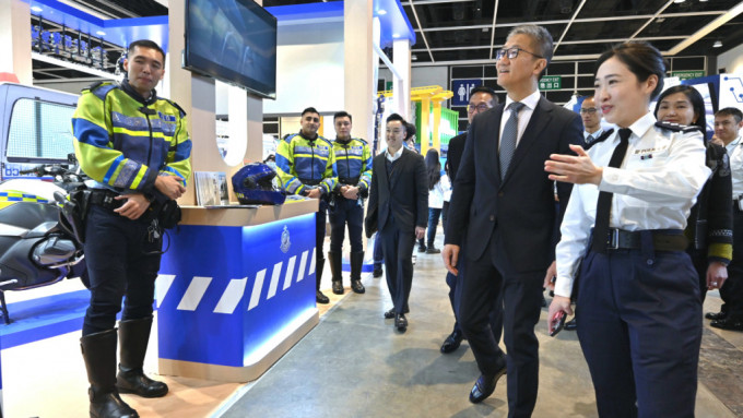 警務處處長蕭澤頤（前排右二）參觀警隊攤位，並聽取招募組人員介紹招募工作。警方圖片