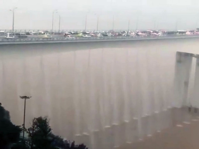 黃花園大橋震撼排洪，雨水順著橋直落江面，有如壯觀的「黃花園大瀑布」。（網圖）