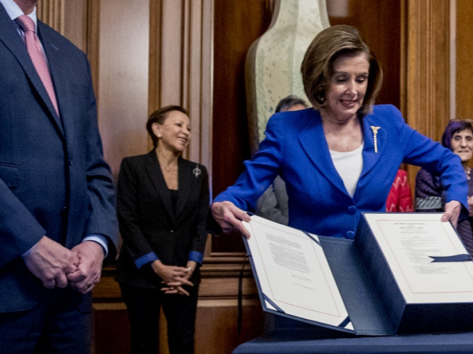 众议院议长佩洛西3天前于国会签署2.2万亿美元纾困方案时，贝拉斯格斯（黑衫者）就站在她身后。AP