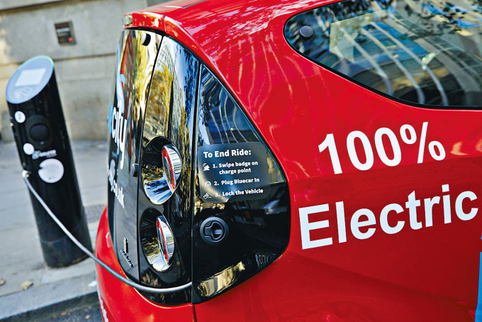 一辆电动车在伦敦使用充电设施充电。