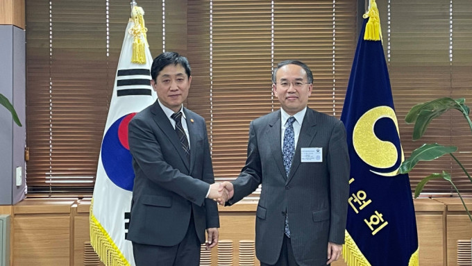 許正宇（右）與韓國金融委員會委員長金周顯（左）會面。（政府新聞處）
