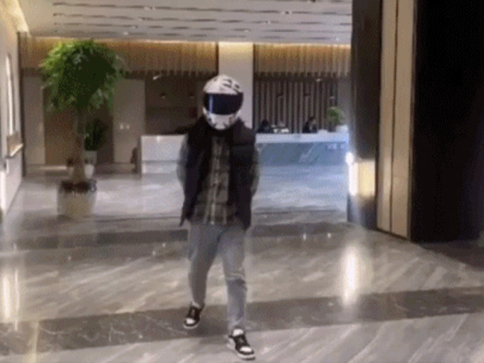 男子戴头盔睇楼的影片在网上热传。（网图）