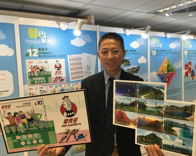 香港郵政高級經理（集郵推廣）李振宇手持明年兩款特別郵票，左為老夫子系列，右為麥里浩徑郵票。