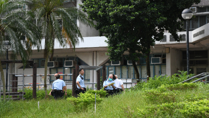 女子堕楼倒卧在草地上，警员在场调查。蔡楚辉摄