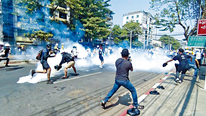 缅甸保安部队周一在仰光发射催泪弹，反政变示威者四散走避。　