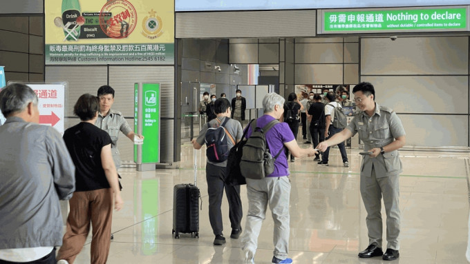 海關人員在口岸派發「旅客過關小錦囊」宣傳單張，提醒旅客切勿攜帶違禁品及受管制物品進出香港。