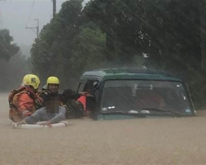私家車幾乎被水淹沒，由消防員救出車內４人。