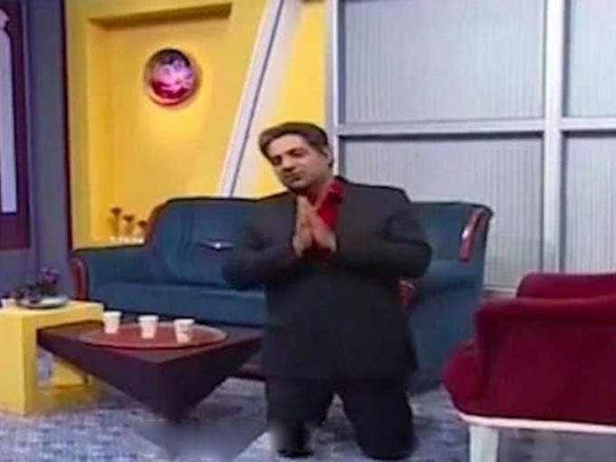 伊朗國家電視台主持人雙膝跪地，雙手合十說道:「我跪下來，懇請你們待在家裡。想想你們自己、家人和孩子。」（網圖）