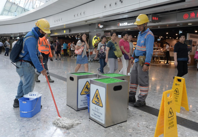 西九龙站在黄雨警告下出现多处漏水，职员更要摆放水桶接载及放置告示牌。资料图片