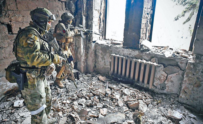 俄兵周二在烏克蘭馬里烏波爾市，遭摧毀的劇院內巡邏。
