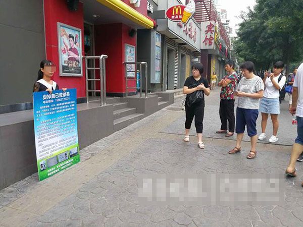 李曉曉上周三（23日）在兒童醫院附近一個路口，舉著寫上「我要賣掉自己」的紙牌，吸引不少途人注意。