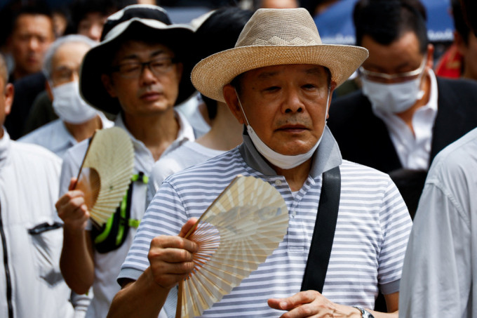 日本今年夏天126年來最熱，民眾外出都要撥扇子。路透社