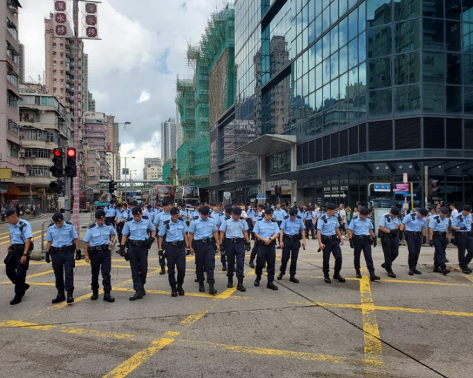 大批藍帽子警員於西九龍中心對開馬路一字排開地毯式搜索。梁國峰攝