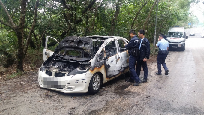 私家車起火後嚴重焚毀，警方在現場調查。 蔡楚輝攝