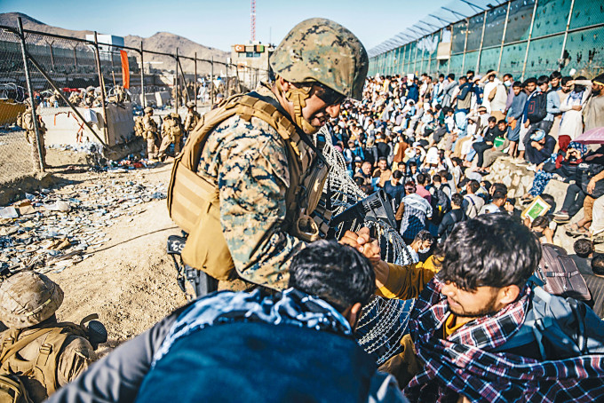 ■一名美军上周四在喀布尔机场的撤离控制检查站，协助撤离工作。