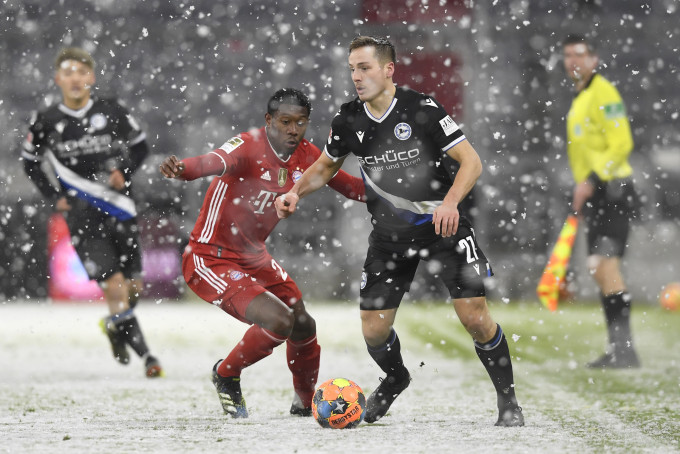 拜仁慕尼黑(红衫)于风雪下主场3:3逼和比勒费尔德(黑衫)。AP