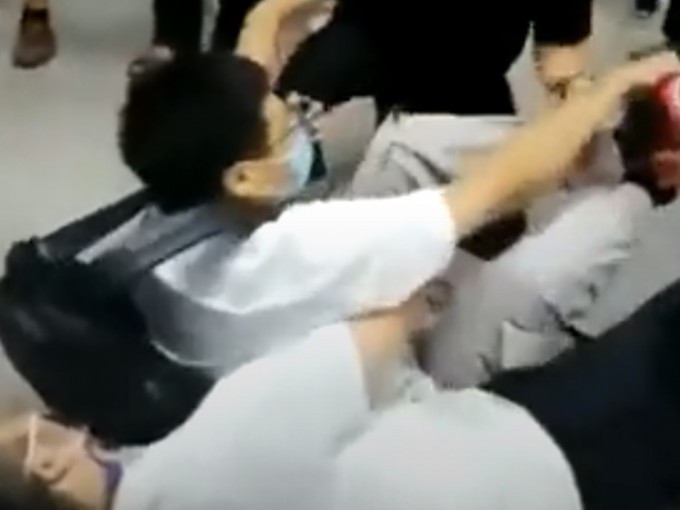 上海一名休班公安人員緊抱住懷疑偷拍男子，協助拘捕行動。影片截圖