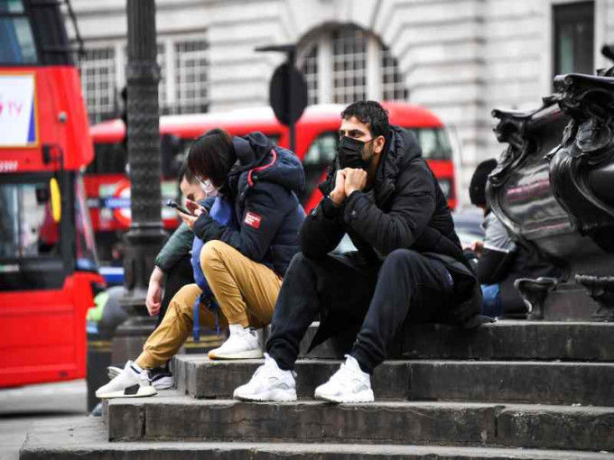英国市民纷戴口罩出街防疫。AP