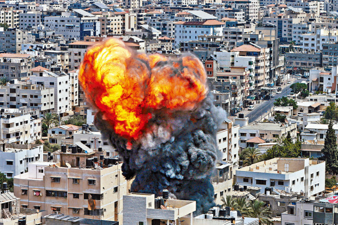 加沙地帶一處建築物昨遭以軍空襲後，冒出火燄和濃煙。