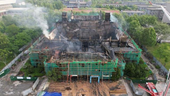 大礼堂经过火灾，房顶已经基本坍塌，被火烧过的建筑呈焦黑状。