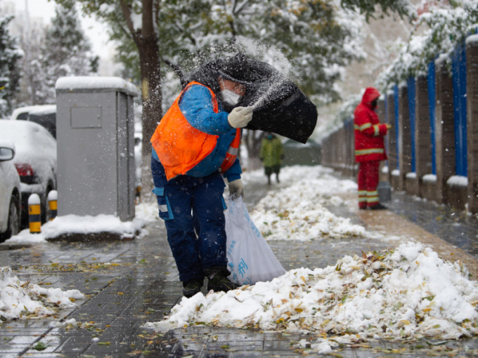 北京市內人員清理積雪。新華社圖片