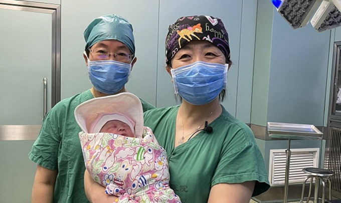 手術室醫護人員與這名來之不易的女嬰合照。互聯網圖片