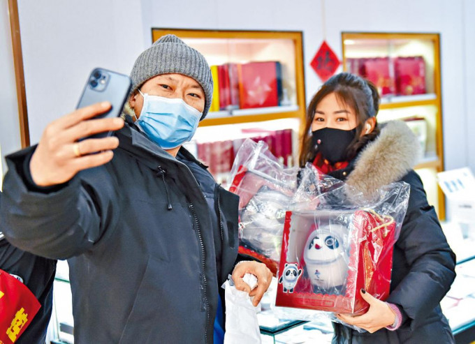 北京市民昨天展示買到的「冰墩墩」毛公仔。
