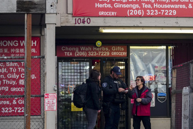 西雅图唐人街连续2日发生多宗持刀伤人案，警员在场调查，向附近店铺东主查问。美联社