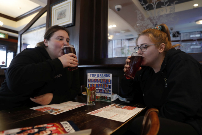英國正如期進行第三階段解封，民眾在酒吧享用啤酒。AP圖片