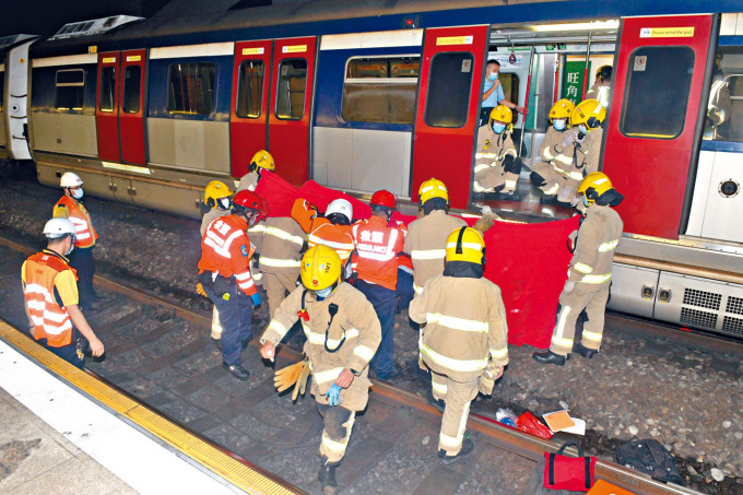 ■消防員在列車車底救出墮軌男子。