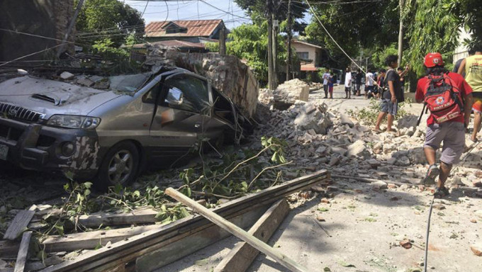菲律賓呂宋島發生強烈地震後，一輛車因牆壁倒塌而受損。AP
