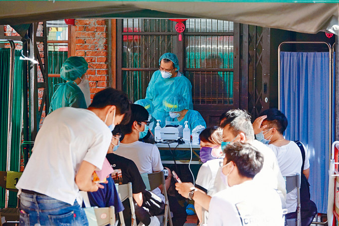 ■台灣疫情持續擴大，民眾日前在篩檢站排隊檢測。