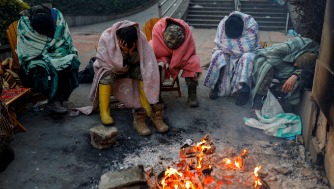 重災區哈塔伊省災民圍在營火旁取暖。 路透社