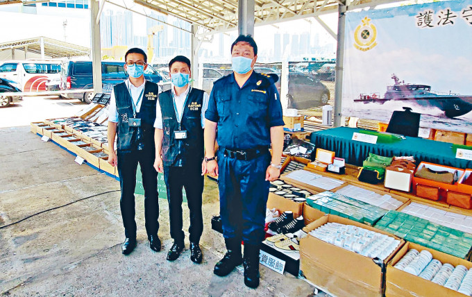 ■海关高级监督胡伟军（中）展示检获今年最大宗海上走私物品。