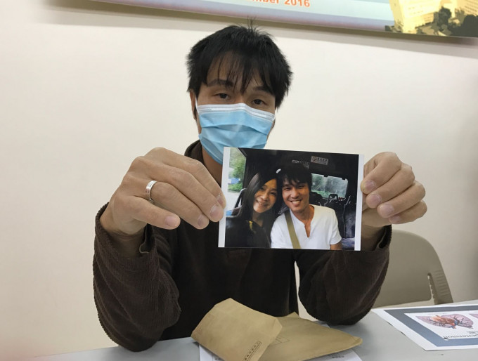 一脸愁容的罗生拿著7、8年前与爱妻的合照。