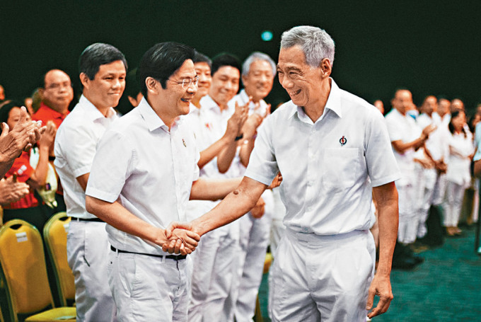 李显龙昨日在人民行动党年会上，与接班人黄循财握手。
