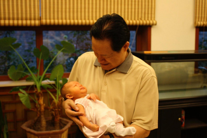 黄婉还贴出两张周永康抱孙的照片，一脸慈祥。网上图片