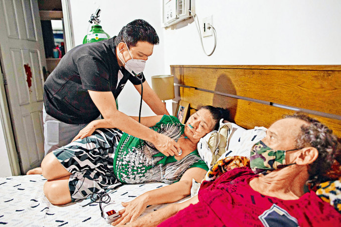 巴西亞馬遜州馬瑙斯市醫院病牀短缺，一名醫生在家為有新冠病徵的母親診治。