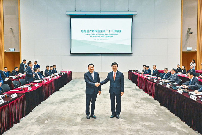 行政长官李家超（右）及广东省省长王伟中在会议前握手。