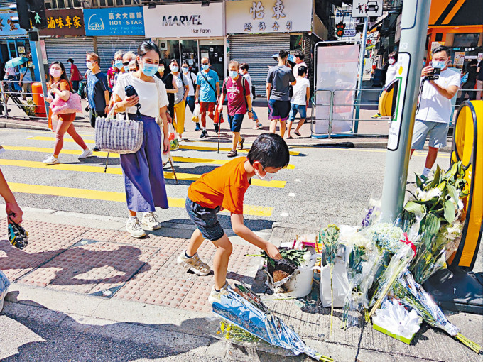 有小童在現場放置鮮花，悼念死者。