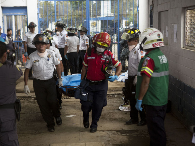 危地馬拉監獄槍擊事件中死亡的囚犯的屍體由消防員帶走。AP