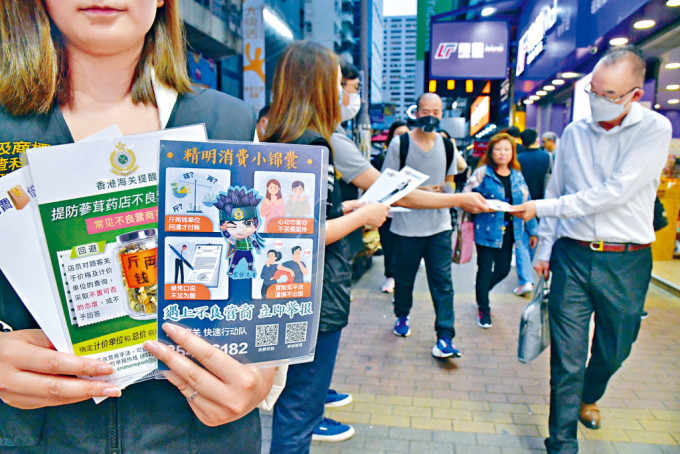 海關在購物熱點向旅客派發宣傳單張，提醒慎防商戶以不良手法營商。