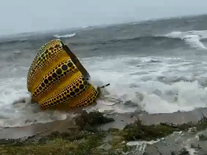 草間彌生的「黃南瓜」遭颱風吹落海面。twitter片段截圖
