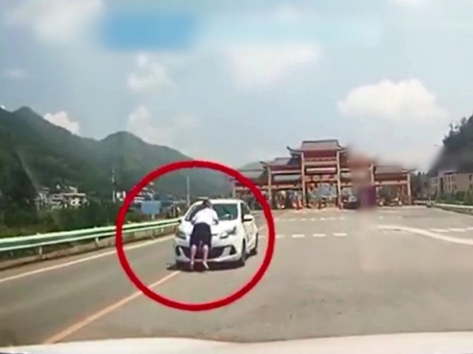 贵州一名女士开车将丈夫顶在汽车的引擎盖上，在高速公路行驶约3公里。　影片截图　