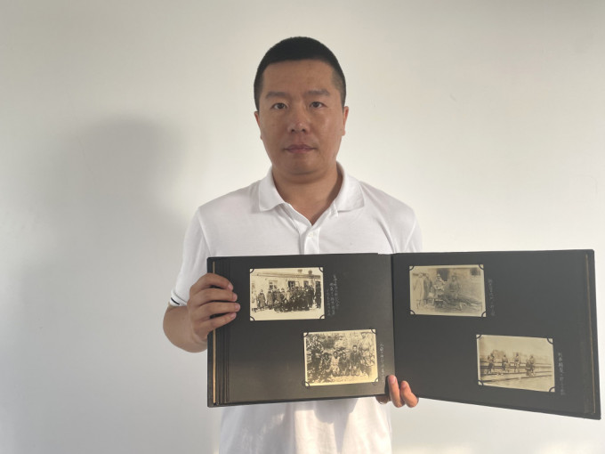 侵华日军第七三一部队罪证陈列馆研究人员金士成展示日军侵华战时照片。(新华社)