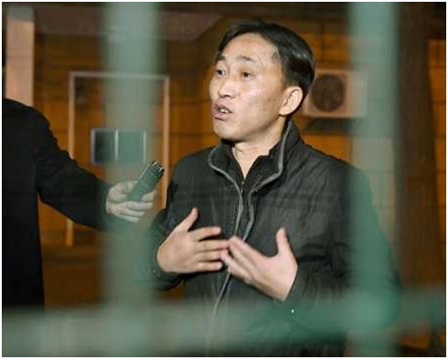 李钟哲在大使馆隔著铁闸接受访问。AP