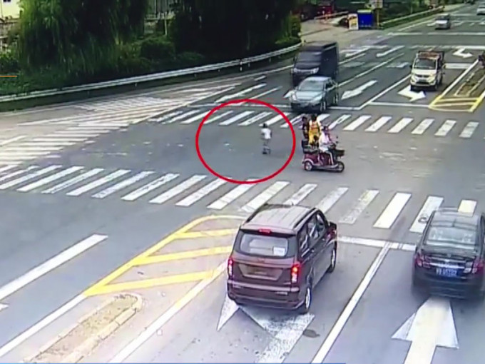 女子騎電動車闖紅燈， 兒子忽跳落車橫衝馬路。(網圖)